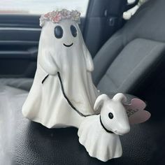 a ghost and dog figurine sitting in the back seat of a car