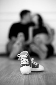 black and white photograph of two people sitting on the floor with their feet up in front of them