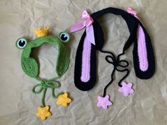 two crocheted hats, one with a frog and the other with a star