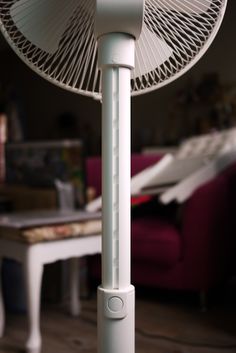 a white fan sitting on top of a wooden floor