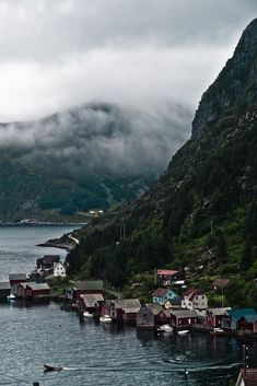 a body of water surrounded by mountains and houses