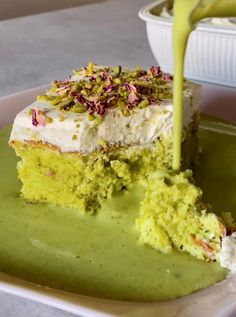 a piece of cake with white frosting and sprinkles is being served on a plate