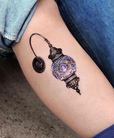 a woman's arm with a tattoo on it that has an ornamental clock design