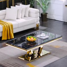 a living room filled with white couches and a black coffee table topped with fruit