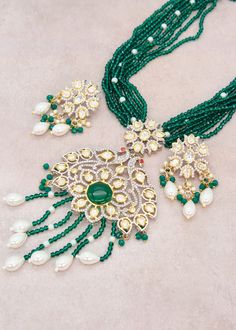 Enhance your special event with the mesmerizing Emerald Green necklace set that showcases Kundan embellishments and a mala made of hydro beads. Make sure to grab this exquisite jewelry piece before it's too late! Necklace Length: 16" Neckline has an adjustable doori. Earring Lenght: 2" Push-Back closure Weight : 12 gms each. Dual-tone finish on high-quality brass as a base metal. Availability: In-Stock. *Color may vary slightly due to light condition & photography. Jewelry Care: Keep away from m Green Necklace Set, Emerald Green Necklace, Photography Jewelry, Phone Items, Mala Necklace, Green Necklace, Exquisite Jewelry, Jewelry Pouch, Necklace Length