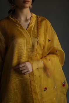 Editor's Note Featuring A-Line Asymmetrical Kurta Set with Hand Embroidered Floral Bootis, Hand Embroidered Beading On The Neckline Color: Mustard Fabric: Zari Tissue - Kurta, Zari Tissue - Pants, Organza - Dupatta, Mulmul Slip Care: Dry Clean Only About the Designer Begum celebrates heritage and rare craftsmanship on traditional silhouettes. Our pieces can be best defined as summer personified with artisanal hand embroideries, hand appliqués and ancient techniques revived in the present day han Tissue Kurta, Tissue Dupatta, Mustard Fabric, Yellow Kurta, Blouse Yoke, Ancient Techniques, A Line Kurta, Kurta Designs Women, Organza Dupatta