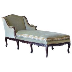 an old fashioned chaise lounge with white upholstered fabric and gold trimming