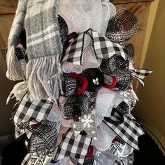 a black and white mesh wreath with red scissors on it's front door for the holiday season