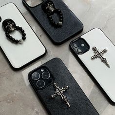 four cell phones with black and white cases, one has a cross on the back