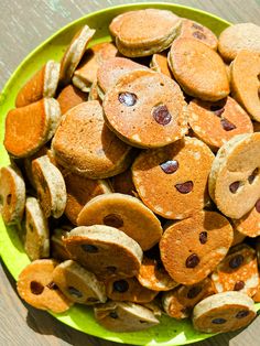 a green bowl filled with pancakes and chocolate chips