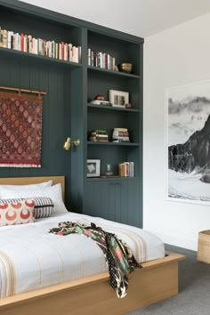 a bed sitting in a bedroom next to a book shelf