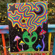 a painting on a wooden chair in front of some trees and bushes with colorful designs