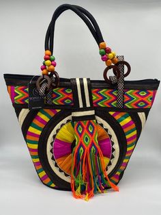 These beautiful handbags are made from Cana Flecha which is an indigenous palm fiber found in the northern territory of Colombia. They are beautifully hand crafted by the people from the Zenu tribes in Colombia. These handbags are colorful with vibrant colors, which is a pure reflection on the region and the warmness of these master artisans that work in this industry every day. Handwoven Palm Leaf Tote Bag, Bohemian Top Handle Bucket Bag For Vacation, Bohemian Top Handle Beach Bag For Travel, Fair Trade Tote Bag For Vacation, Fair Trade Palm Leaf Bag For Vacation, Traditional Handwoven Top Handle Bag, Bohemian Straw Bag With Handles, Bohemian Multicolor Beach Bag With Leather Handles, Traditional Tote Beach Bag For Travel