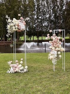 three tall white and pink flower arrangements in the grass