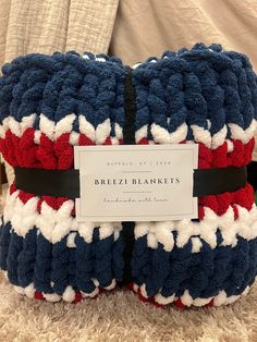 the blanket has been made to look like it is knitted with red, white and blue yarn