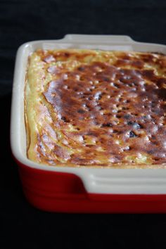 a red and white container filled with food sitting on top of a table next to a black surface