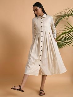 A box pleated cotton silk front open jacket with long sleeves and collar, kota yoke at the back Garment measurements (in Inches): Small: Bust - 39", Waist - 37" Medium: Bust - 42", Waist - 40" Large: Bust - 45", Waist - 43" Length: 47", Sleeve length: 20" Fabric: Cotton Silk Color: Ivory Fit: Model height is 5'7" Model is wearing a size S Loose and comfortable fit. Instructions: Hand wash separately in cold water Note: Available in other colors Pants not included with the product Pants can be bo