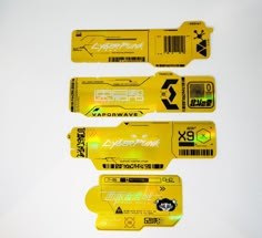 three yellow tags with black and white designs are on a white surface next to each other