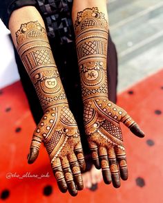 two hands with henna designs on them, one is holding the other's hand