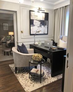 a living room filled with furniture and a painting on the wall over a computer desk