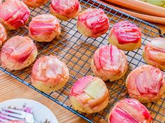 some food is sitting on a cooling rack next to a plate with other foods and utensils