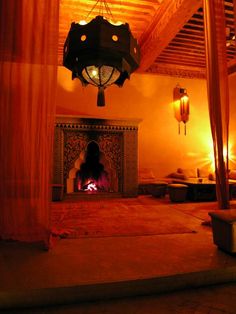 a living room with a fire place in the center and curtains on the ceiling above it