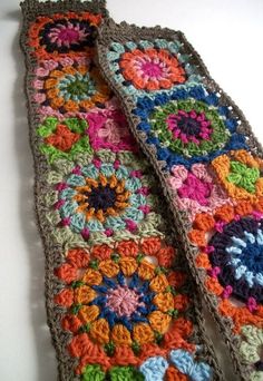 a crocheted neck tie with multicolored flowers on the end is laying on a white surface