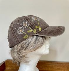 a brown hat with flowers on it sitting on top of a mannequin head