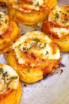 several mini pizzas with cheese and herbs on them