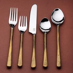 five spoons, two forks and one knife on a brown surface