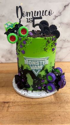 a monster truck themed cake with green frosting and purple sprinkles on top