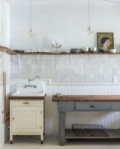 a kitchen with a sink, counter and shelves on the wall next to each other