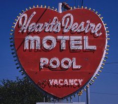 a large red heart shaped motel sign on the side of a building