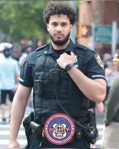 a police officer standing in the middle of a street with his hand on his hip