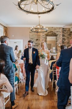 a bride and groom walking down the aisle