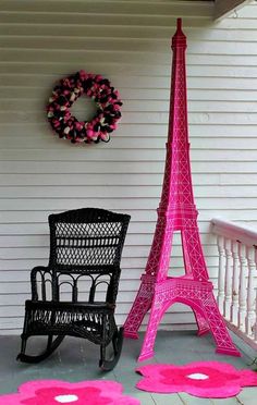 the pink rugs are on the porch next to the eiffel tower and chair