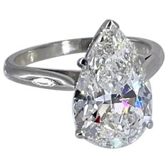 a pear shaped diamond ring on a white background