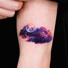 a woman's arm with a tattoo on it that has an image of the moon and clouds