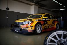 an orange and yellow car parked in a garage