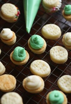 cookies with green icing and white frosting are on a cooling rack next to an umbrella