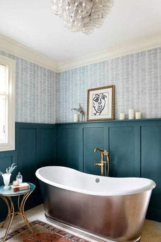 a bathtub in a bathroom with blue walls and a rug on the floor next to it