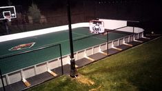 an outdoor basketball court is lit up at night