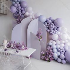 a dining room with balloons and flowers on the wall, along with a white table