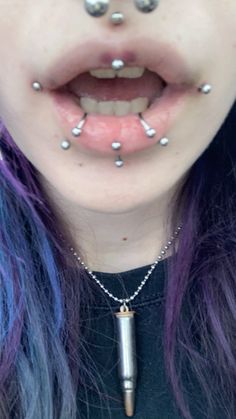 a woman with purple hair and piercings on her nose