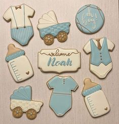 baby boy cookies decorated with blue and white icing are arranged in the shape of babies'clothes