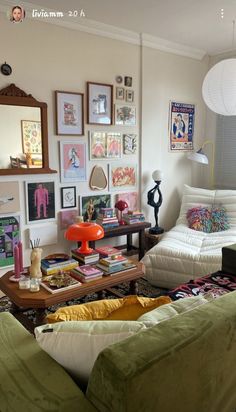 a living room filled with lots of furniture and pictures on the wall next to a coffee table