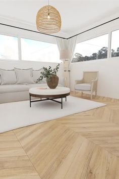 a living room with white furniture and wood flooring in front of two large windows