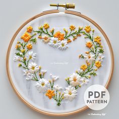 a heart made out of daisies is shown in the hoop