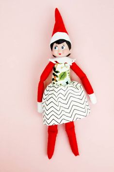 the elf doll is wearing a white dress and red hat