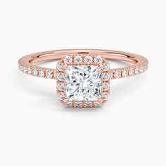 a rose gold engagement ring with a princess cut diamond in the center and pave set shoulders